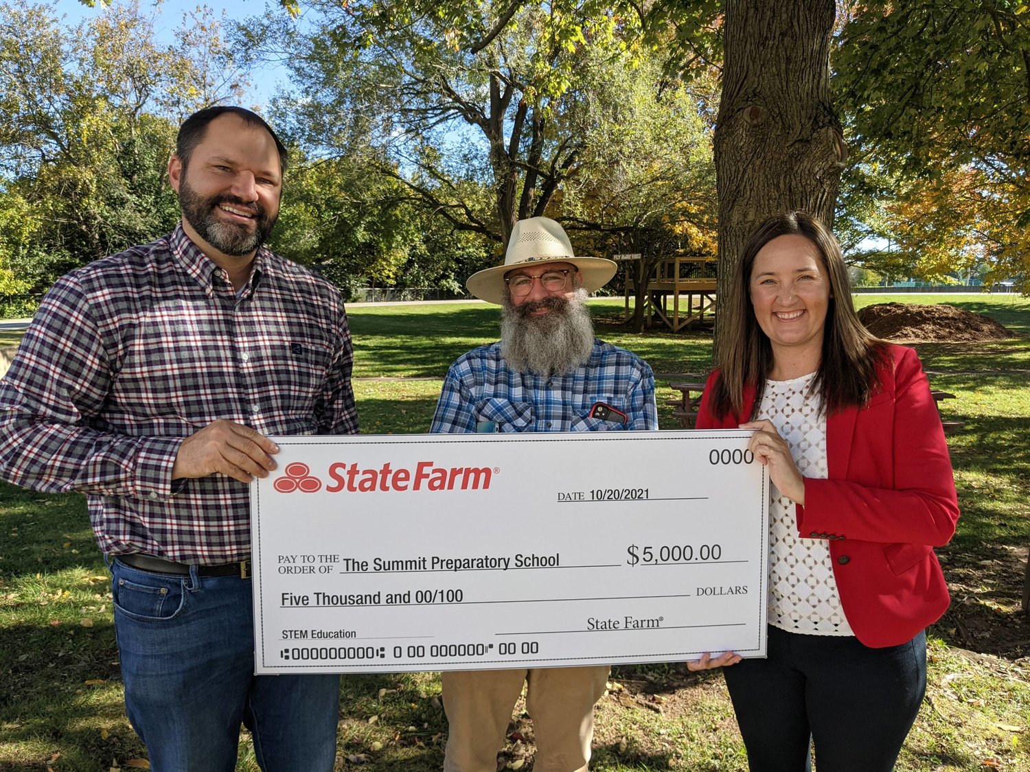 From left, Jordan Heinz of State Farm presents a grant check to Summit's Rob Powers and Katie Heet.